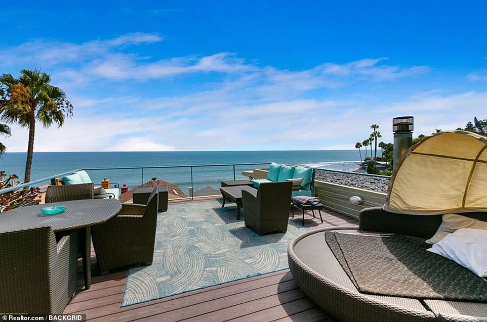 Ocean view: Set above a two-car garage, the main house features two levels of spacious wooden decks, with a gorgeous over-the-rooftop view of the palm tree-lined Pacific Ocean