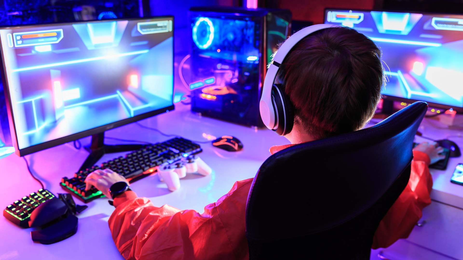 A person wearing headphones and sitting at a computer
Description automatically generated